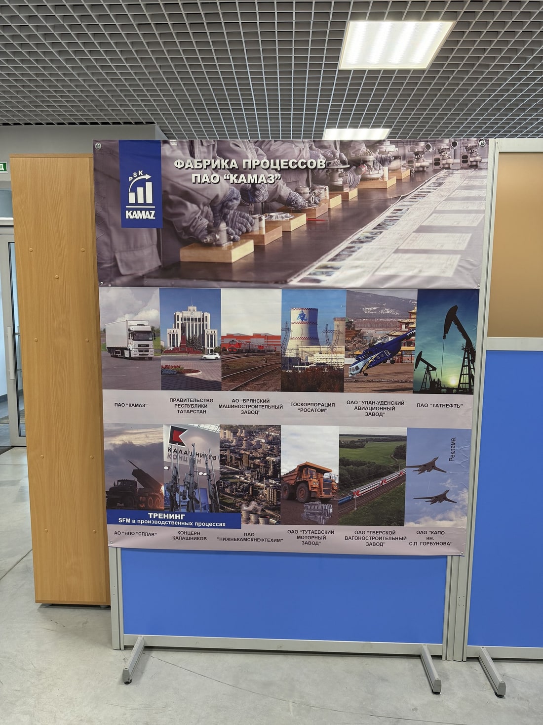 Стенд «Фабрика процессов ПАО КАМАЗ» с фотографиями и названиями компаний-участников: Росатом, Татнефть, Концерн Калашников, КАПО имени Горбунова и другие Стенд «Фабрика процессов ПАО КАМАЗ» с фотографиями и названиями компаний-участников: Росатом, Татнефть, Концерн Калашников, КАПО имени Горбунова и другие
